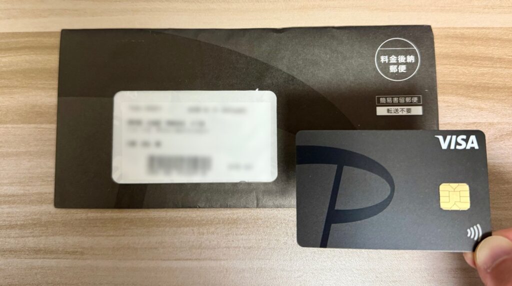 手に持ったPayPayカードと郵送された時の封筒