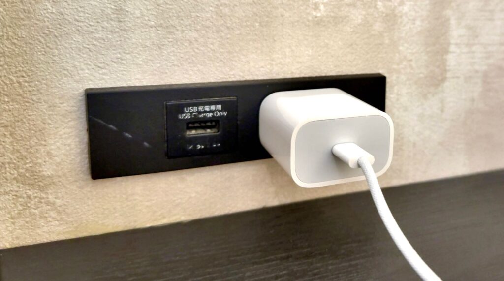 カフェラウンジNODOKAの個室内のコンセントに充電器が挿された様子